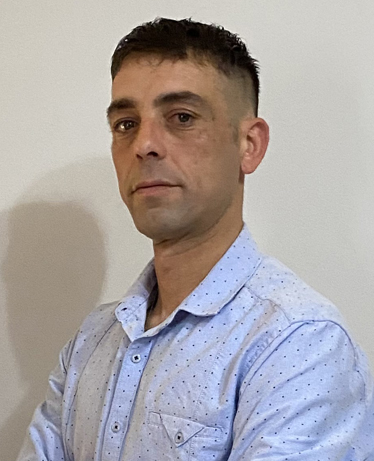 Ritratto in primo piano del consigliere comunale Rotolini con camicia azzurra su sfondo chiaro